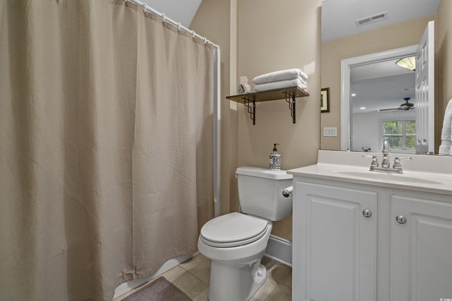 Bathroom with vanity, ceiling fan, tile patterned floors, and curtained shower | Image 32
