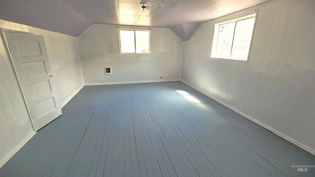 Bonus room featuring dark wood finished floors, vaulted ceiling, wood walls, and heating unit | Image 19