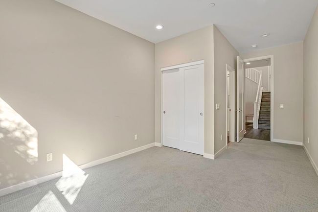 Nice sized ensuite bedroom at entry level near one of the outside entrances and the garage. | Image 5