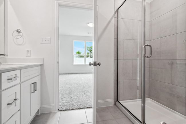 Full bath featuring vanity, a stall shower, and light tile patterned floors | Image 18