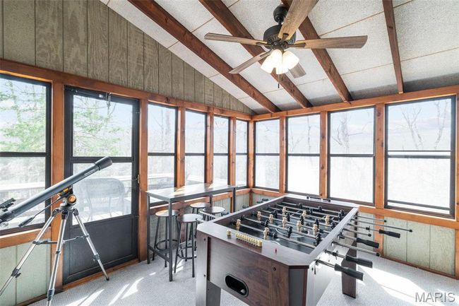 Recreation room featuring carpet flooring, a ceiling fan, and vaulted ceiling with beams | Image 30