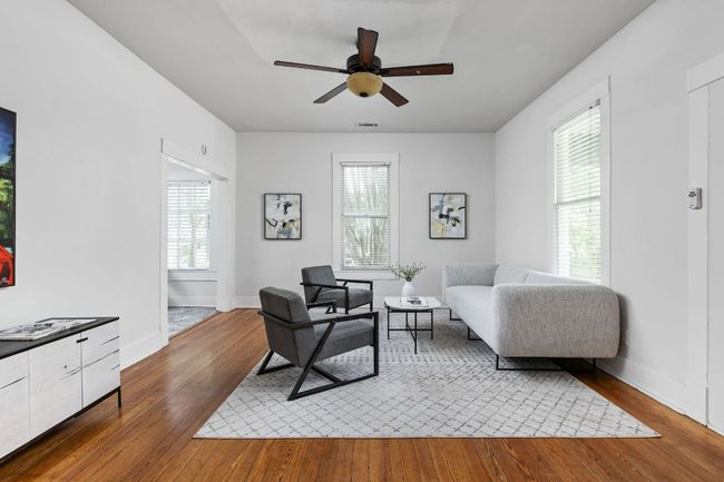 Living area featuring a healthy amount of sunlight, ceiling fan, wood-type flooring, and baseboards | Image 5