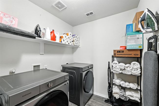 Laundry area featuring washing machine and clothes dryer and wood finished floors | Image 22