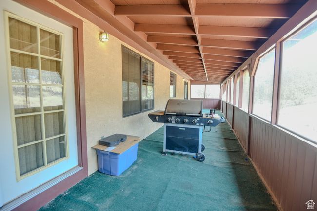 Unfurnished sunroom featuring beamed ceiling | Image 12