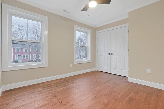 Airy second bedroom with ornamental molding, double wide closet and ceiling fan. | Image 29