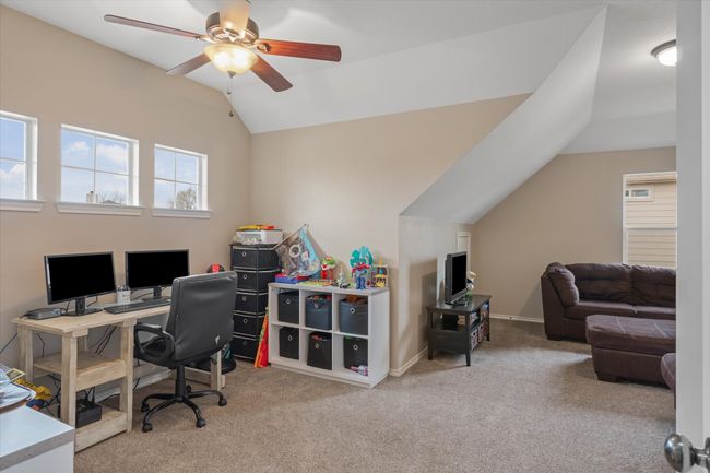 Home office with vaulted ceiling, carpet, a ceiling fan, and baseboards | Image 25