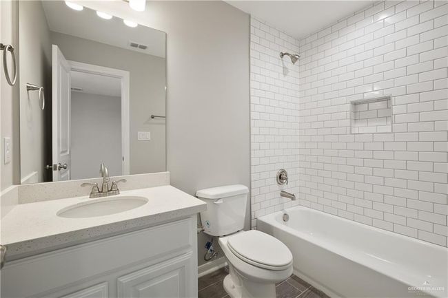 Full bathroom with vanity, toilet, shower combination, and baseboards | Image 9