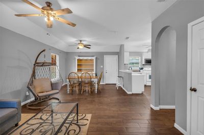 Dining space featuring dark wood-type flooring, sink, and ceiling fan | Image 2