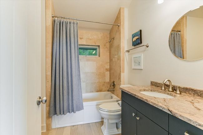 Bathroom featuring vanity, shower / bathtub combination with curtain, and wood finished floors | Image 31