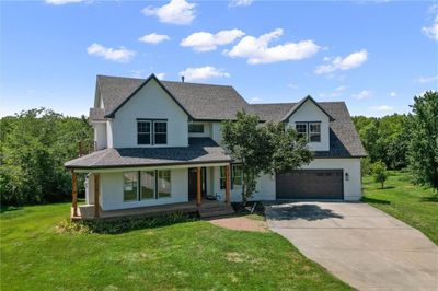 View of front of property with a garage, a porch, and a front lawn | Image 1