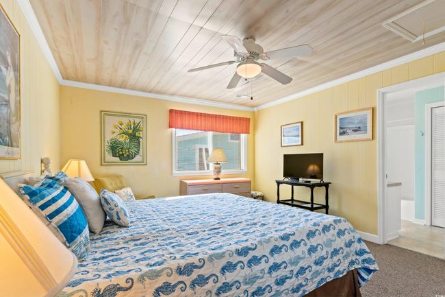 Bedroom featuring carpet flooring, ceiling fan, crown molding, and wooden ceiling | Image 21