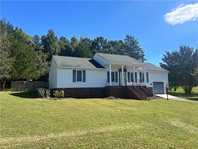 View of front of home with a garage, a porch, and a front yard | Image 1