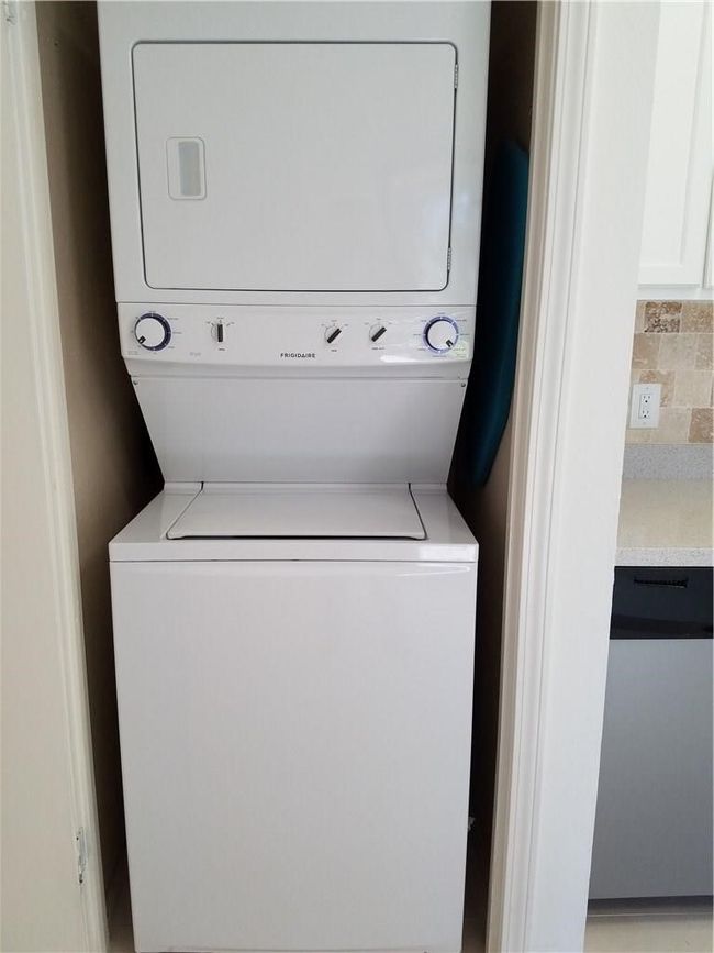 Clothes washing area featuring stacked washer / drying machine | Image 10