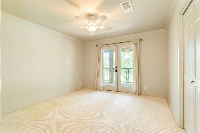 This secondary bedroom also includes a set of French doors, adding character and natural light to the cozy space | Image 31