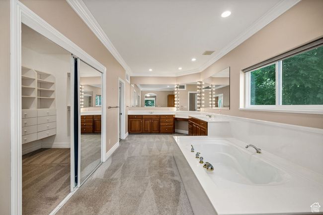 Bathroom featuring vanity, a bath, ornamental molding, and recessed lighting | Image 16