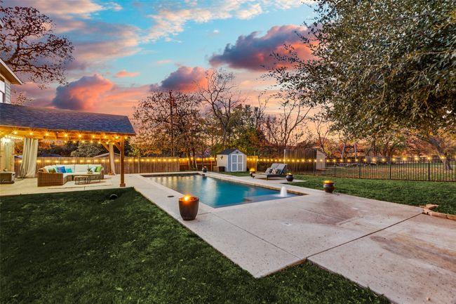 View of swimming pool featuring an outdoor hangout area, a storage unit, a patio area, and a fenced backyard | Image 25