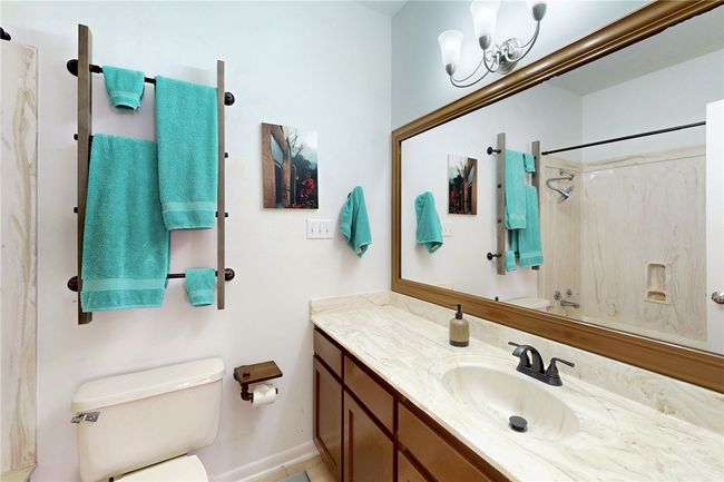 Bathroom featuring toilet, vanity, a chandelier, and baseboards | Image 21