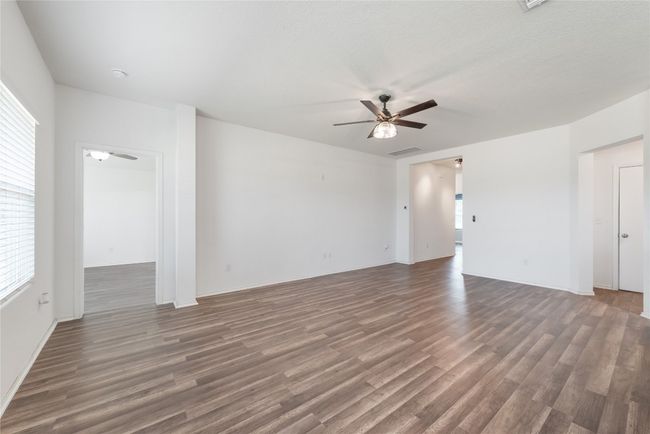 Unfurnished living room with a ceiling fan and wood finished floors | Image 10