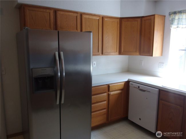 Large side-by-side refrigerator and dishwasher add utility to the kitchen. | Image 12
