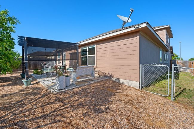 View of property exterior with fence, a patio, a gate, and a pergola | Image 21
