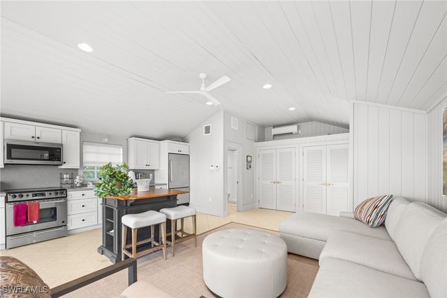 Boathouse is reimagined as guest cottage with vaulted ceiling, sofa bed, kitchen, washer/dryer, and bathroom | Image 42