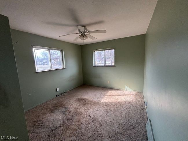 Carpeted empty room featuring ceiling fan | Image 9