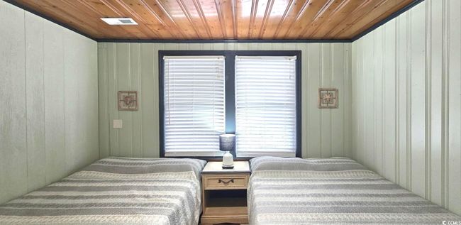 Bedroom featuring wood ceiling and wood walls | Image 29