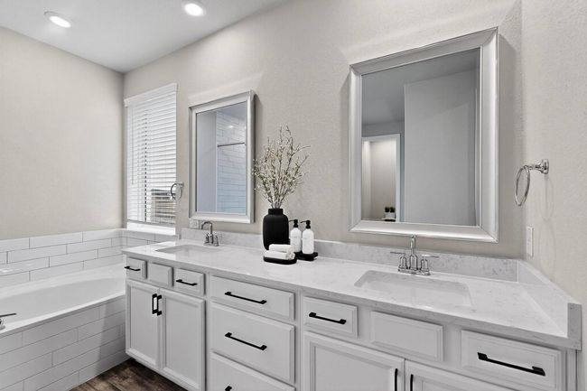 Bathroom featuring double vanity, a bath, dark wood-style flooring, and recessed lighting | Image 17