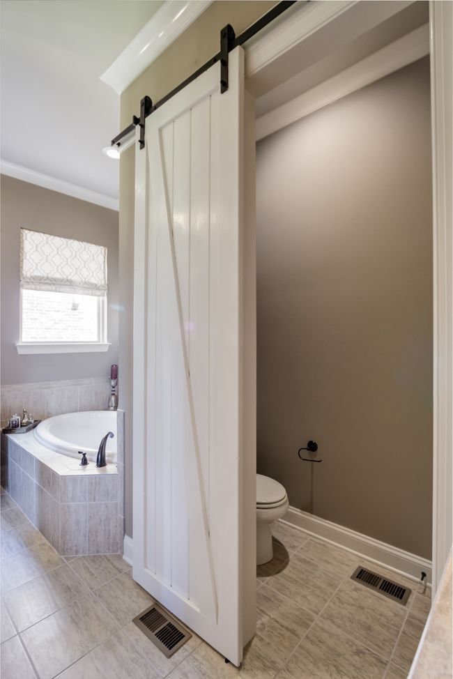 The primary bathroom also features a barn door to the water closet. | Image 37