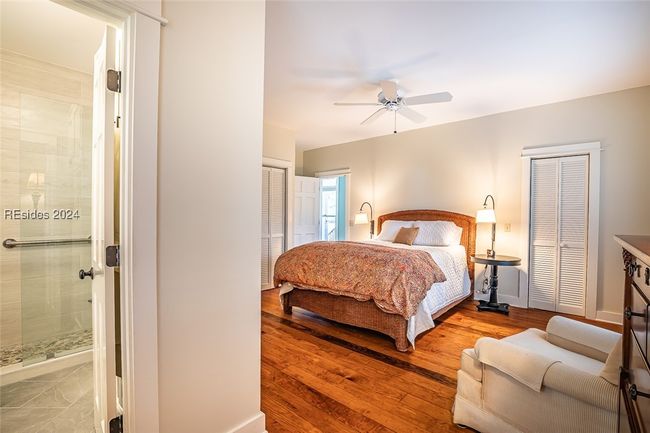 Bedroom featuring multiple closets, wood-type flooring, and ceiling fan | Image 30