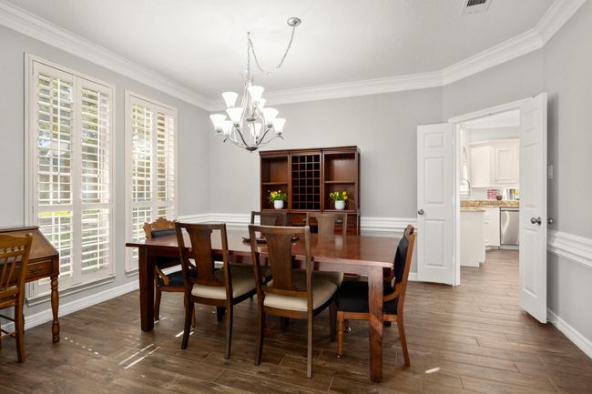 Dining room flows to the kitchen through the double doors. Shutters, chandelier and gorgeous trim/moldings are timeless. | Image 8