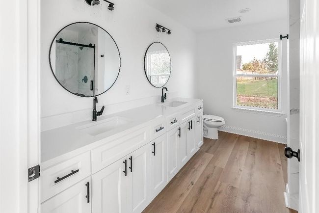 Full bathroom with toilet, visible vents, a sink, and wood finished floors | Image 16