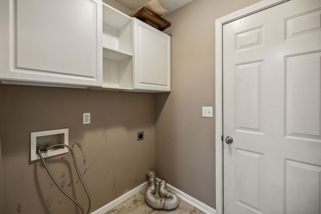 The utility room features practical laminate flooring and ample cabinetry, offering both durability and abundant storage solutions for all your household needs. 2095 Bolden Drive, Murfreesboro, TN 37127 | Image 14