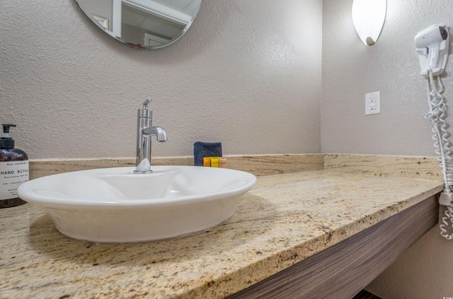 Bathroom featuring a textured wall and vanity | Image 9