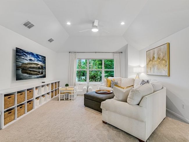 Carpeted living area featuring a ceiling fan, recessed lighting, vaulted ceiling, and visible vents | Image 13
