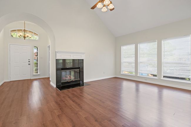 Large living area with vaulted ceiling and fireplace with gas logs. | Image 4