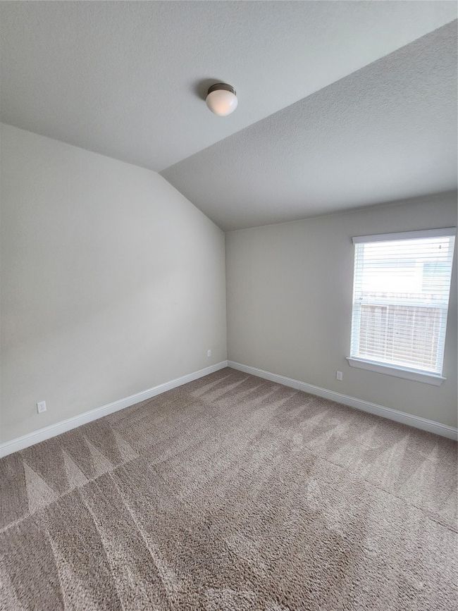 Empty room with carpet, vaulted ceiling, and a textured ceiling | Image 22