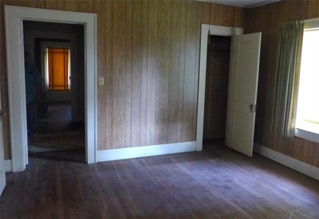 Vintage Charm Meets Renovation Potential! Featuring original wood paneling and hardwood floors, this space is ready for a fresh vision. This sunlit room offers original details and a solid foundation—ready for your creative vision. | Image 4
