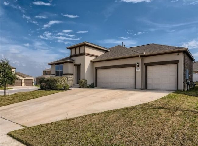 Prairie-style home with an attached garage, stucco siding, driveway, a shingled roof, and a front yard | Image 17