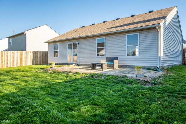 back of house featuring a shingled roof, a yard, a patio area, and fence | Image 5
