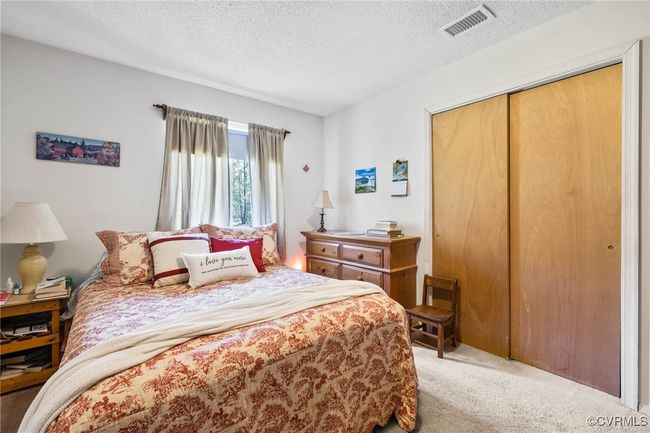 Carpeted bedroom featuring a closet, visible vents, and a textured ceiling | Image 15