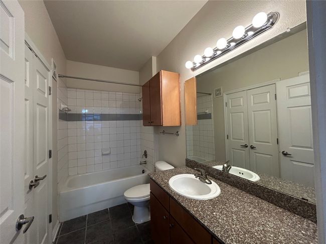 Bathroom with shower combination, vanity, toilet, and tile patterned floors | Image 13
