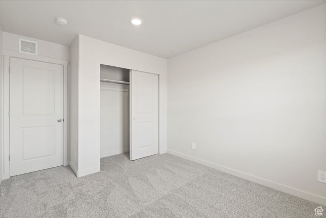 Unfurnished bedroom with light carpet, a closet, and recessed lighting | Image 41