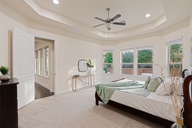 Bedroom featuring a raised ceiling, carpet flooring, recessed lighting, and ceiling fan | Image 19
