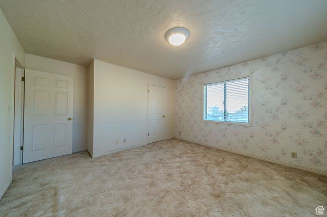 Empty room featuring wallpapered walls, carpet flooring, and baseboards | Image 25