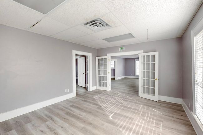 Unfurnished room with a paneled ceiling, wood-type flooring, and french doors | Image 14
