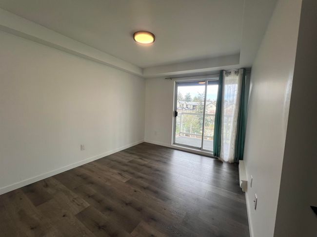 Empty room with dark wood-type flooring and a raised ceiling | Image 25