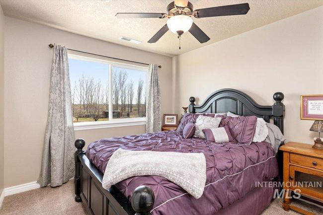 Bedroom with light carpet, a ceiling fan, and a textured ceiling | Image 18