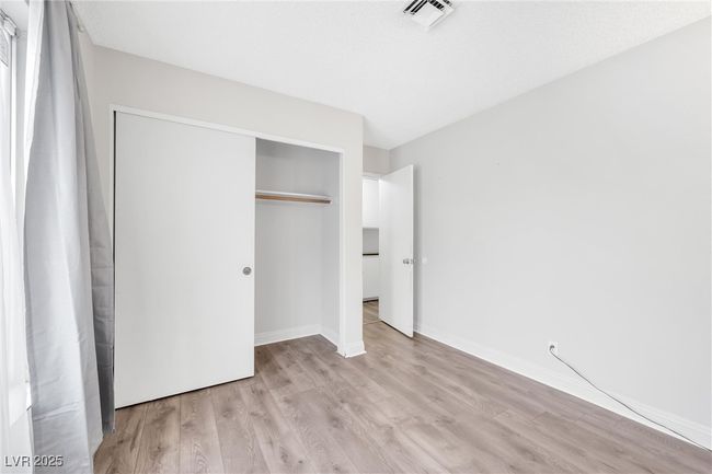 Unfurnished bedroom with visible vents, a closet, baseboards, and light wood-style floors | Image 14