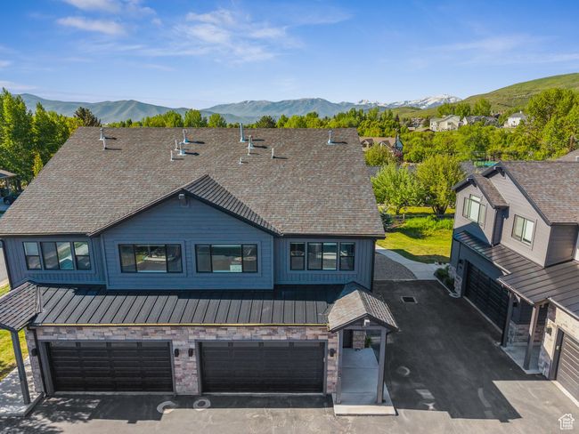 View of front facade featuring a standing seam roof, an attached garage, a mountain view, metal roof, and board and batten siding | Image 54